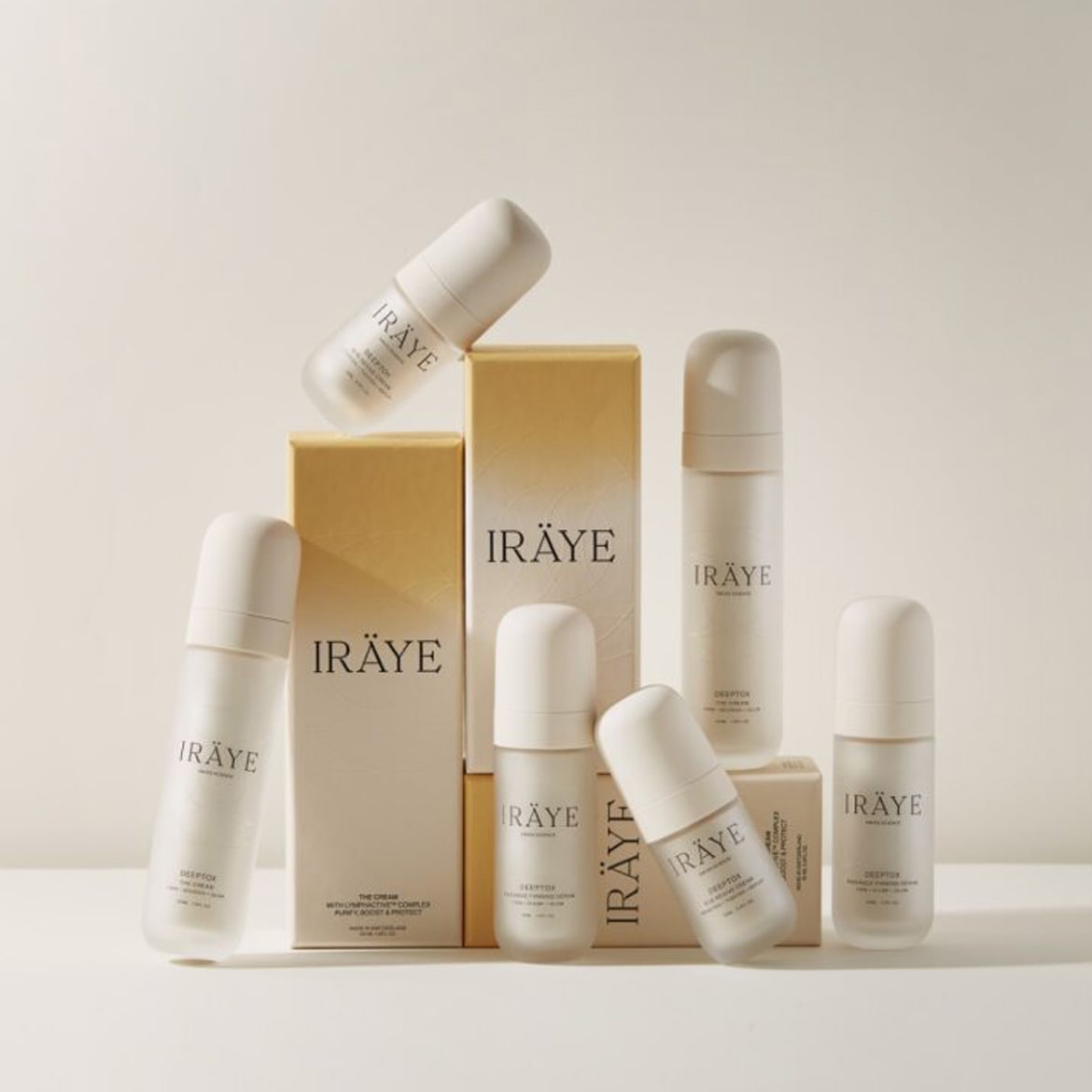 A collection of Iräye skincare products, featuring creams and serums in minimalist white and gold packaging, designed to purify, boost, and protect your skin.