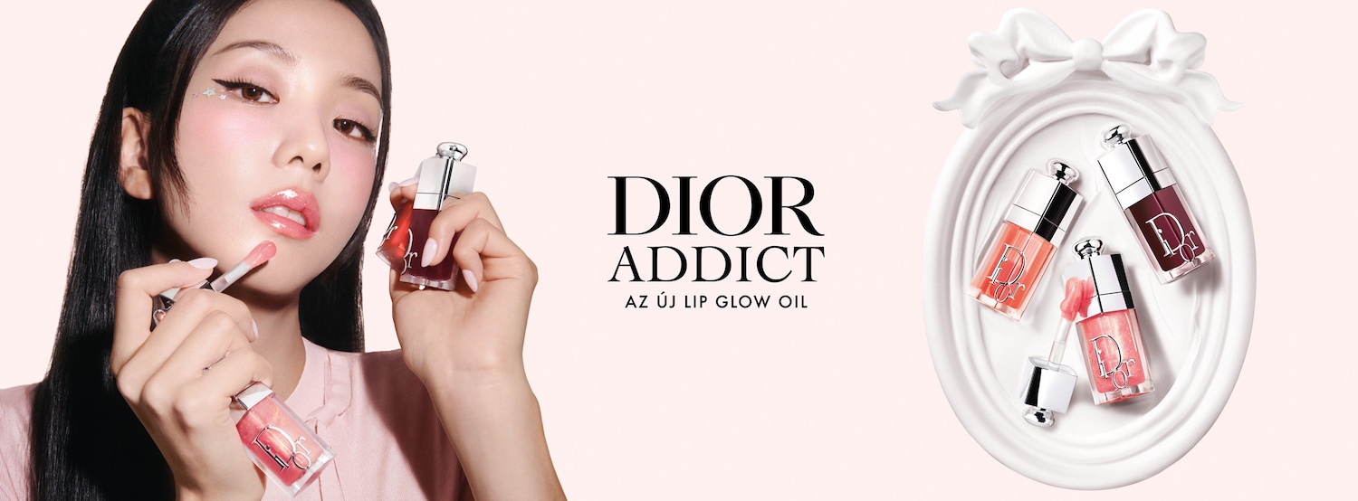 A Dior Addict új Lip Glow Oil termékét egy nő viseli, aki a szájára viszi az átlátszó, rózsaszín árnyalatot, miközben a termék különböző színei egy fehér tálcán láthatók.