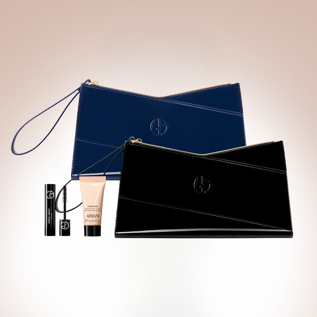 Két fényes, lakkozott Giorgio Armani kuplung, egy fekete és egy kék színben, valamint egy szempillaspirál és egy alapozó tubusa látható.