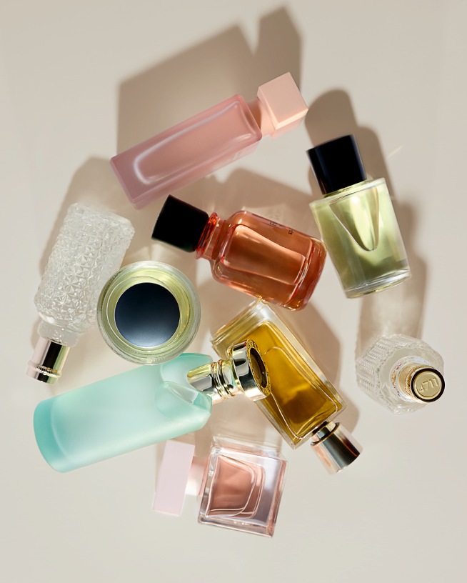 Fedezzen fel egy művészi kompozícióban megörökített parfümös üvegek gyűjteményét, melyek változatos árnyalatokban, a púderrózsaszíntől a tengerzöldig terjednek.