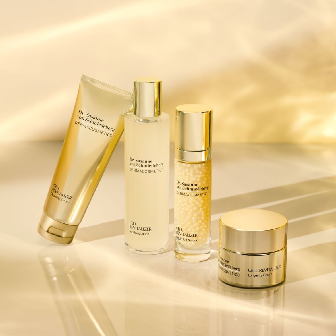 A Dr. Susanne von Schmiedeberg DERMACOSMETICS termékek arany színű csomagolásban: arctisztító krém, nyugtató lotion, folyékony lifting szérum és longevity krém.