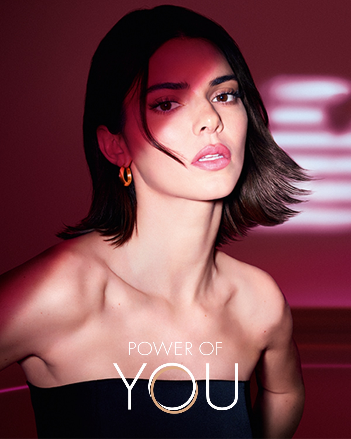 A képen egy barnahajú nő látható, aki fekete, pánt nélküli felsőt visel, és arany karika fülbevalót hord, a kép alján a "POWER OF YOU" felirat olvasható.